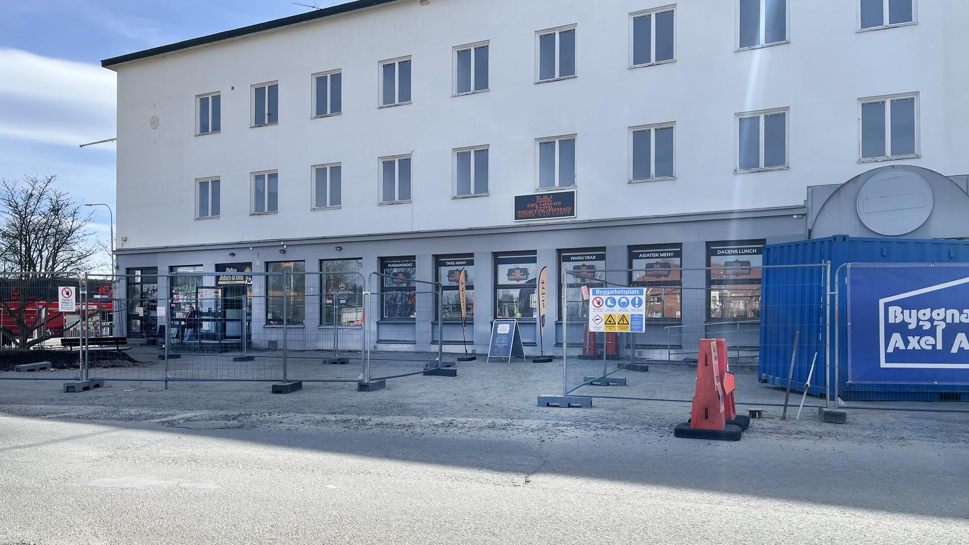 Entre i byggstängsel mitt fram på fasaden