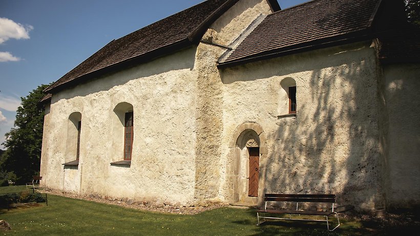 Vit gammal kyrkobyggnad i sten.