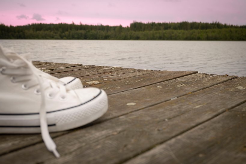 Skor på brygga i kvällsljus