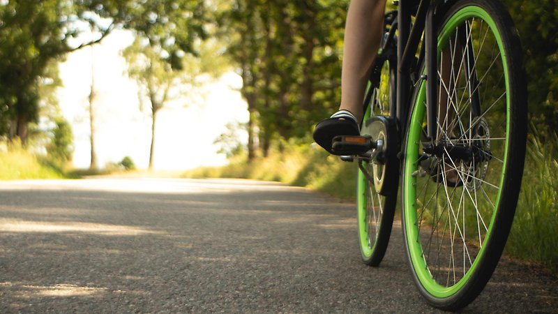 Detaljbild på cykelhjul på asfaltsväg